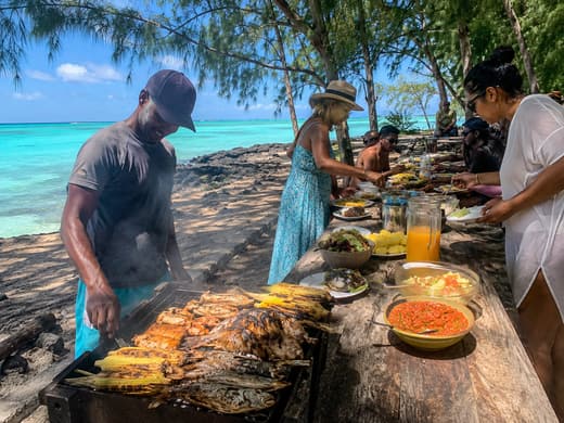 Barbecue mauricien pr&eacute;par&eacute; sur la plage devant les invit&eacute;s