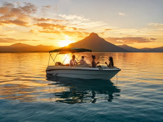 Bateau d&rsquo;excursion au coucher du soleil devant une montagne mauricienne