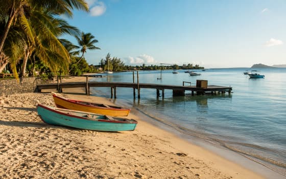 Pirogues et ponton sur une plage mauricienne au calme
